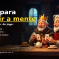 Rei do Jogos do Rei e um amigo riem jogando cartas numa mesa de madeira, com peças de dominó, bule e xícaras de chá, numa cozinha aconchegante iluminada pela lareira